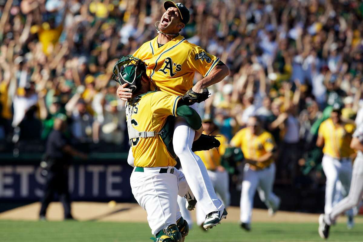 Oakland Athletics relief pitcher Grant Balfour, top, and catcher Derek Norris celebrate after their 12-5 win over the Texas Rangers in a baseball game, Wednesday, Oct. 3, 2012 in Oakland, Calif. The A's clinch the AL West title with the win. (AP Photo/Ben Margot)
