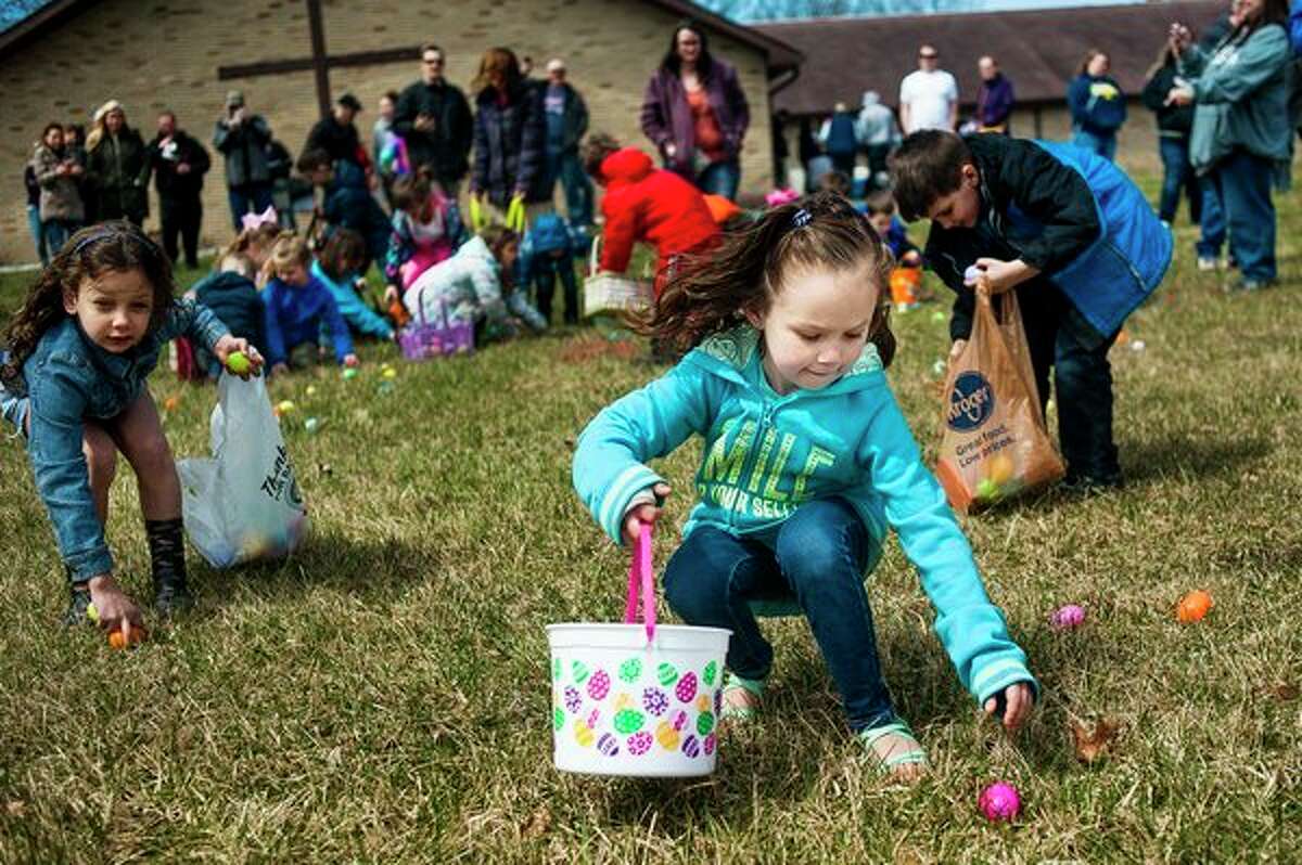 FILE PHOTO: Beverleigh Bentley of Saginaw County reaches down for an egg during an Easter egg hunt  at Faith Wesleyan Church in Midland.