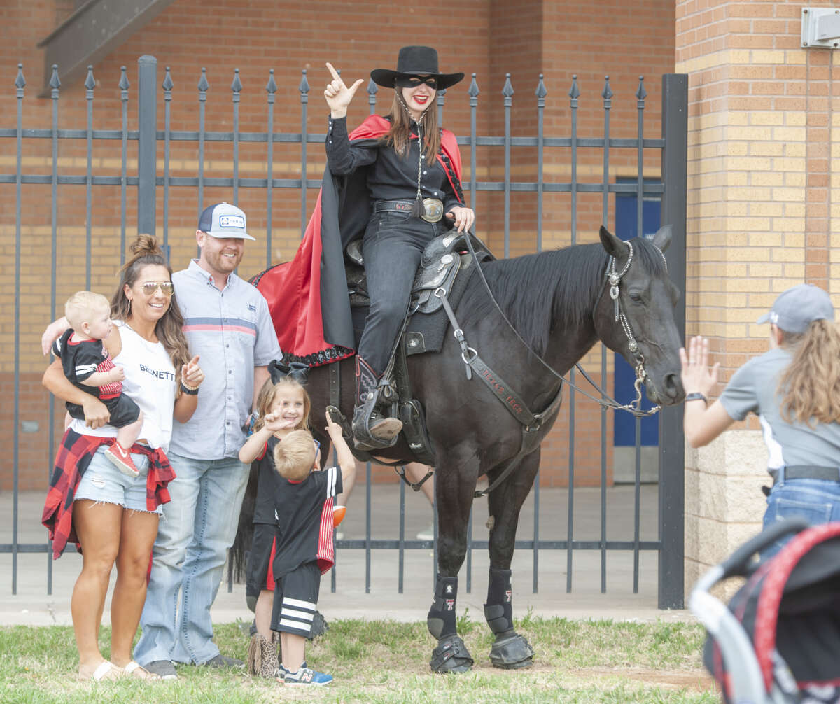 Texas Tech University fans and supporters take a picture with the Masked Rider April 5 before the annual football scrimmage at Grande Communications Stadium. The mascot was unmasked on Friday during a ceremony at the Lubbock campus. Lyndi Starr served as Masked Rider for 2018-19, and has handed over the reins to Emily Brodbeck.