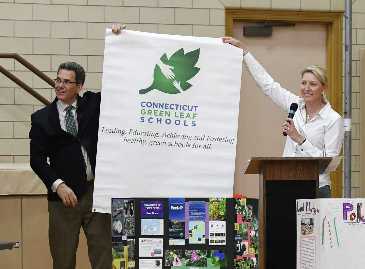 Principal Christopher Weiss and teacher Audrey Barrett celebrate Riverside School's new recognition as a CT Green Leaf School by the COEEA during the Earth Day kickoff event at Riverside School in the Riverside section of Greenwich, Conn. Monday, April 22, 2019. At the event, Principal Christopher Weiss shared stories of his spring vacation to several National Parks, the Riverside Chorus performed a Navajo poem, students shared their STEM Fair projects on plant life and air pollution, and the .