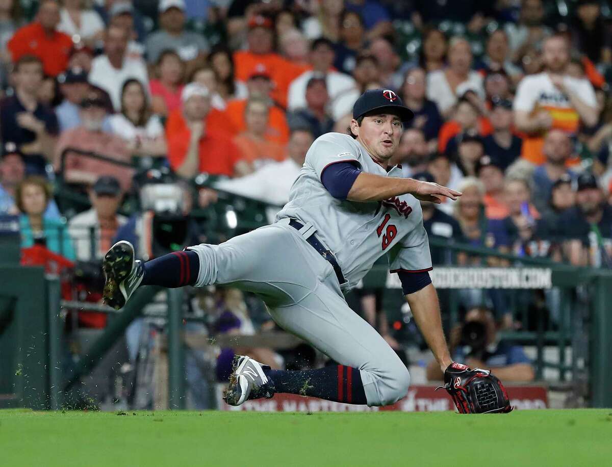 Minnesota Twins relief pitcher Ryne Harper (19) falls backward making the throw to first as Houston Astros Josh Reddick ground out during the sixth inning of an MLB baseball game at Minute Maid Park, Tuesday, April 23, 2019, in Houston.