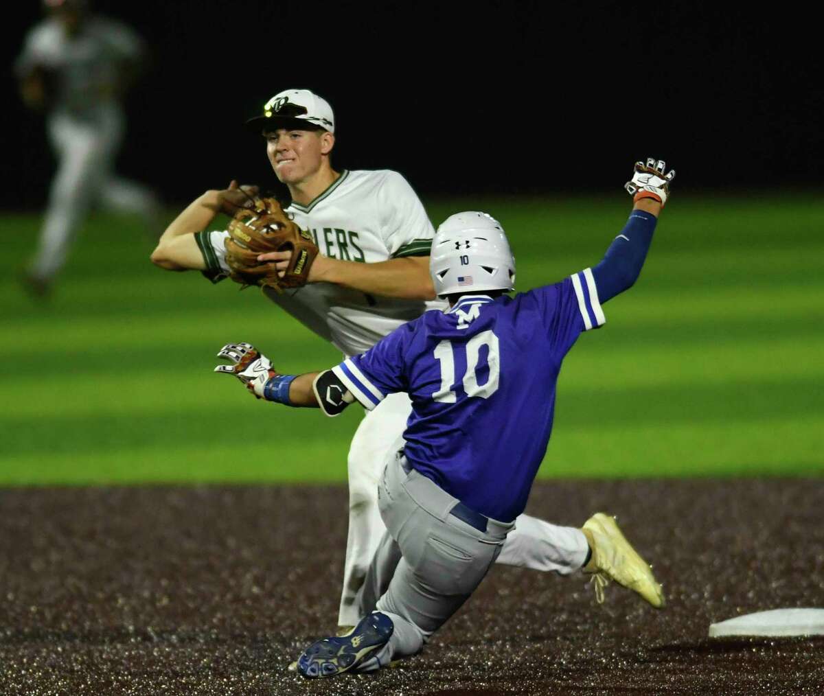Reagan second baseman Jacob Burcham turns a double play as MacArthur's Jacob Gilbert slides in to end the game during the 27-6A baseball action at the NEISD Sports Park on Tuesday, April 23, 2019.