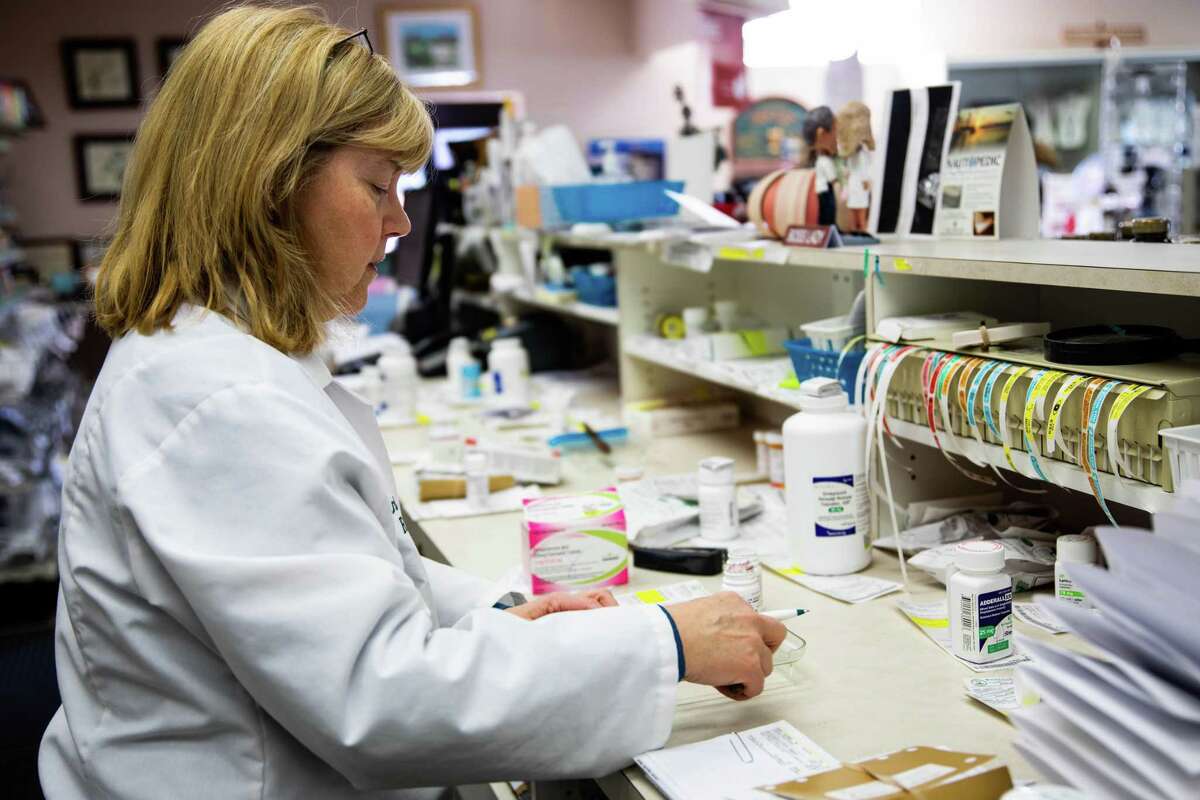 Marion Bradley, 57, lead pharmacist and co-owner of Beacon Falls Pharmacy, fills a prescription.