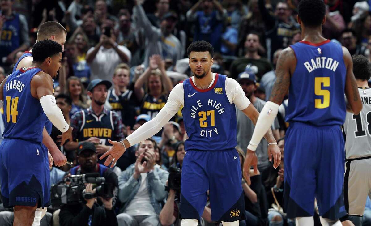 Denver Nuggets guard Jamal Murray (27) celebrates a play with teammates Gary Harris (14) and Will Barton (5) in the first half of Game 5 of an NBA basketball first round playoff series against the San Antonio Spurs, Tuesday, April 23, 2019, in Denver. (AP Photo/David Zalubowski)