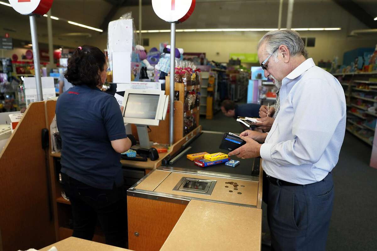 Don Kagin gets ready to pay with rare coins while shopping at a drugstore while taking part in the Great American Coin Hunt in Tiburon, Calif., on Monday, April 22, 2019.