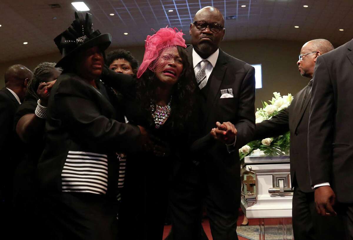 Roxane Freeman, center, is helped away from her husband’s coffin during the funeral service at the Greater Grace Outreach Church on July 29, 2017, in Houston. Heywood Freeman and the couple’s two children were killed in a crash July 21, 2017, along Beltway 8.
