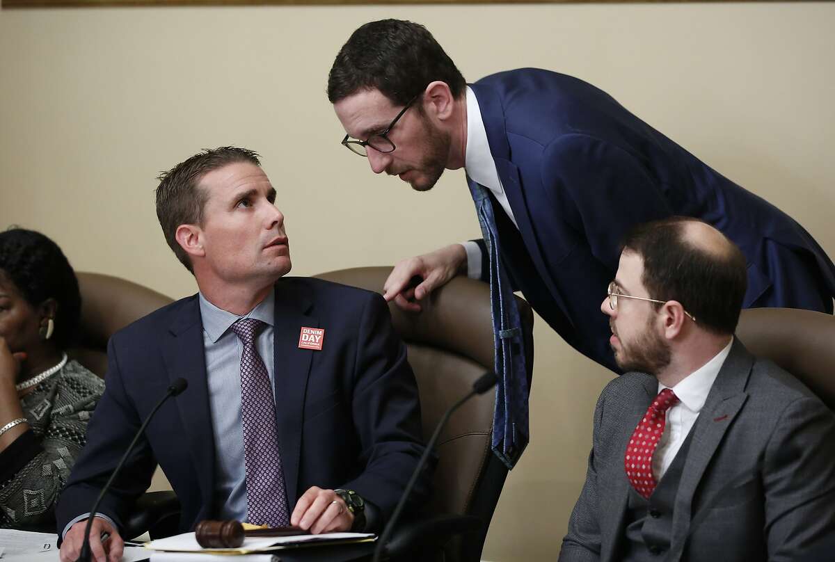 State Sen. Mike McGuire, D-Healdsburg, left, confers with State Sen. Scott Wiener, D-San Francisco, center, during a hearing on their housing bills Wednesday, April 24, 2019, in Sacramento, Calif. McGuire merged his bill, SB4 with Wiener bill, SB50 that would increase housing near transportation and job hubs. The bill was approved by the Senate Governance and Finance Committee. (AP Photo/Rich Pedroncelli)