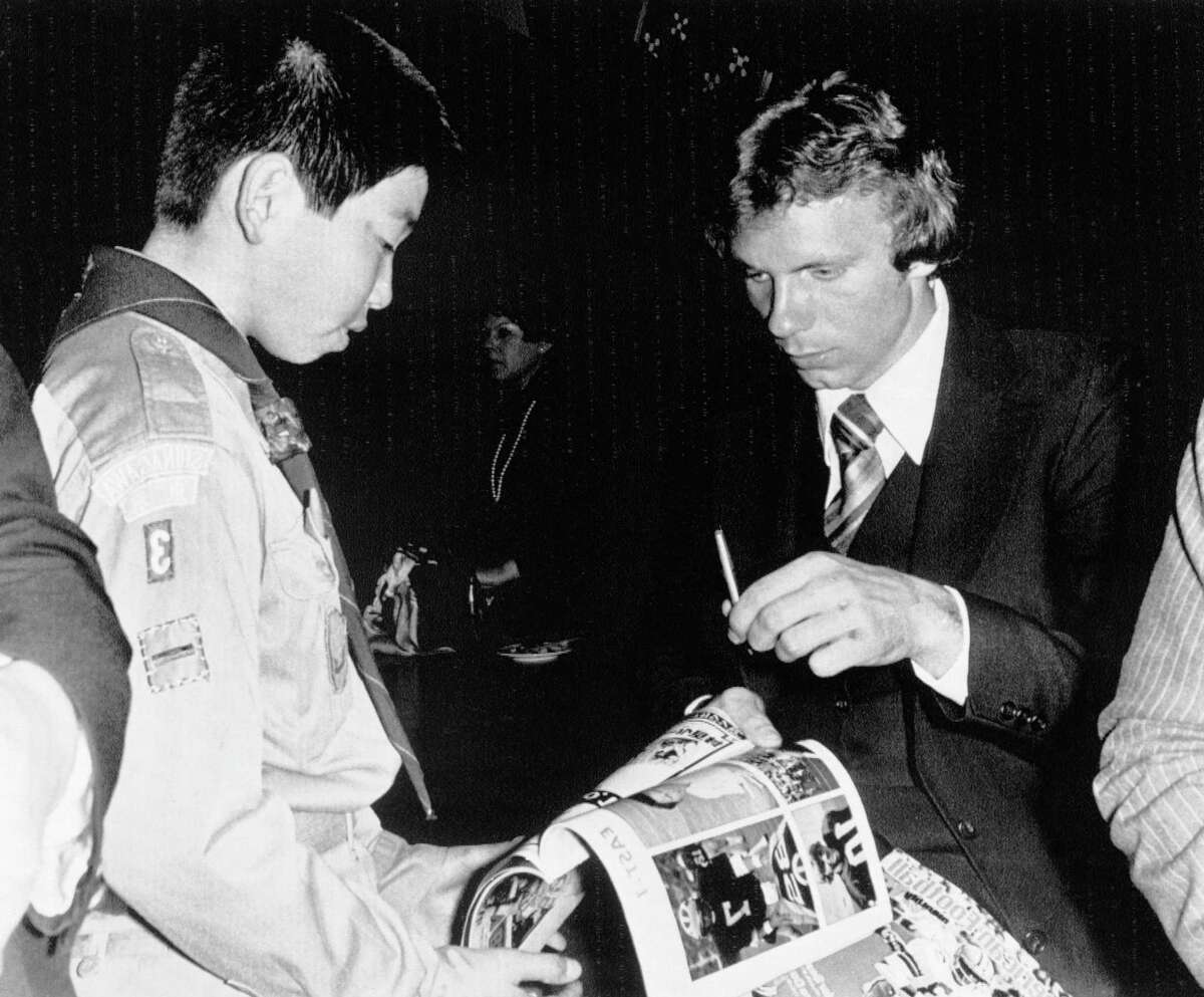 Joe Montana of Notre Dame University, right, autographs a program for a young Japanese boy scout during reception at a Tokyo hotel on Tuesday, Jan. 10, 1979. Montana is a member of the East team that will meet a West team in the fourth Japan Bowl American collegiate all-star football game on Sunday in Tokyo. (AP Photo/LI)