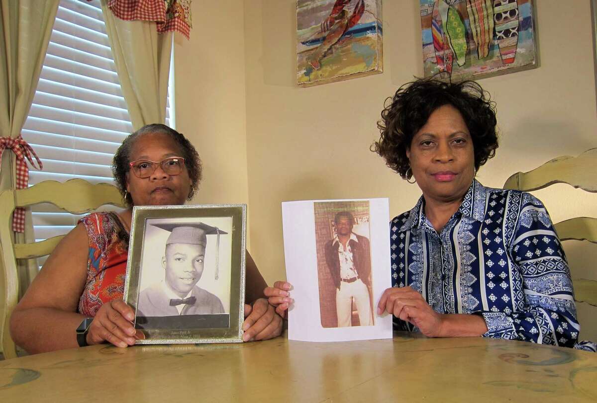 Mylinda Byrd Washington, 66, left, and Louvon Byrd Harris, 61, hold up photographs of their brother James Byrd Jr., who in 1998 was lynched in Jasper, Texas, by racists who chained him to a pickup truck and dragged him to death.