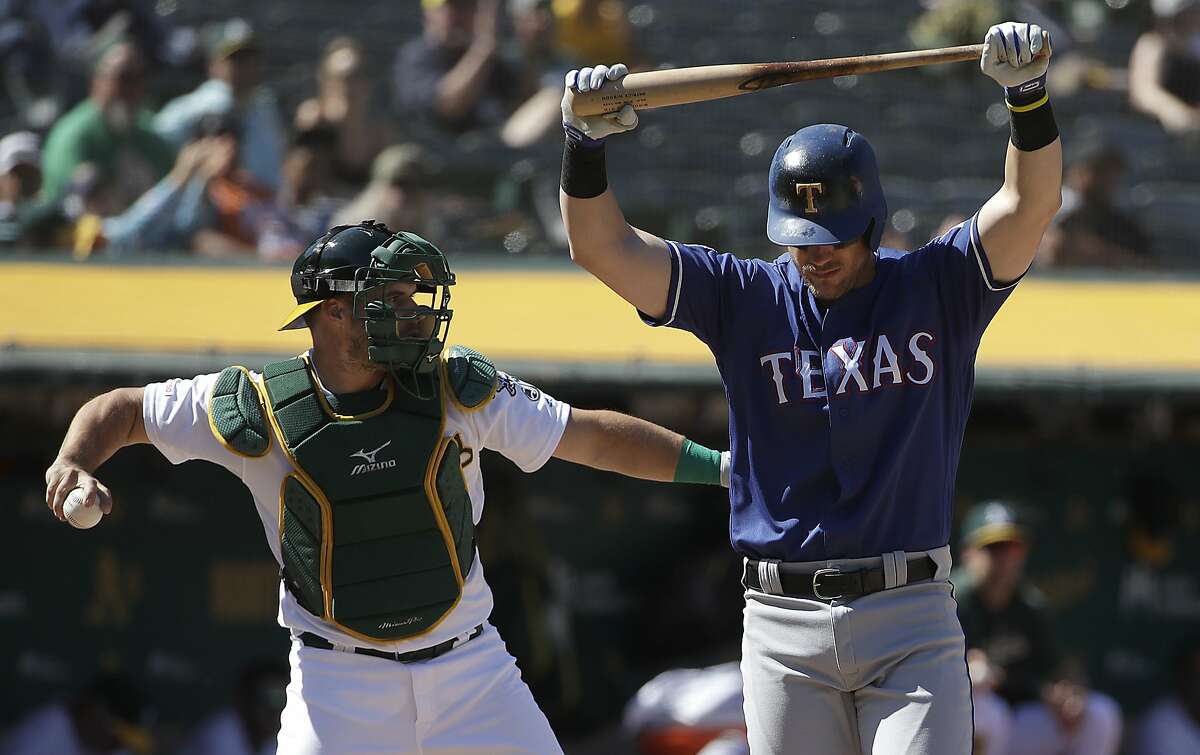 Texas Rangers' Patrick Wisdom, right, reacts after striking out in front of Oakland Athletics catcher Josh Phegley during the ninth inning of a baseball game in Oakland, Calif., Wednesday, April 24, 2019. (AP Photo/Jeff Chiu)