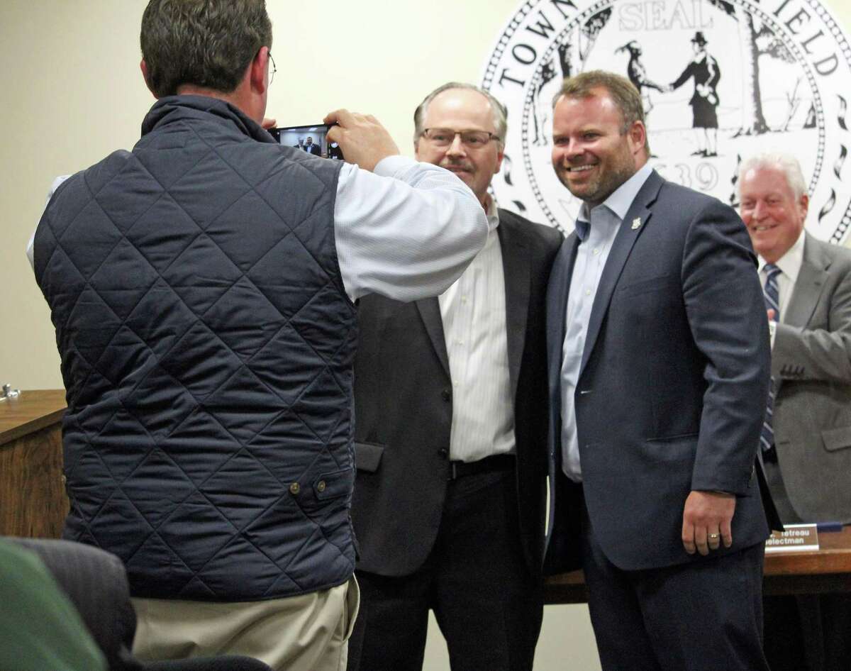 Republican Town Committee Chairman James Millington takes a photo of Selectman Edward Bateson, left, and Selectman Chris Tymniak, right, after Bateson was put back on the board. First Selectman Mike Tetreau looks on at Wednesday's baord meeting. Fairfield,CT. 6/6/18