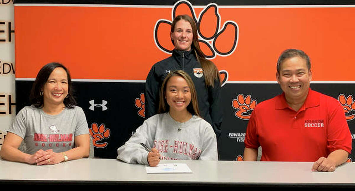 EHS senior Katrina Agustin, seated center with her parents, will play women’s soccer at Rose-Hulman. Standing is Edwardsville girls’ soccer coach Abby Federmann.