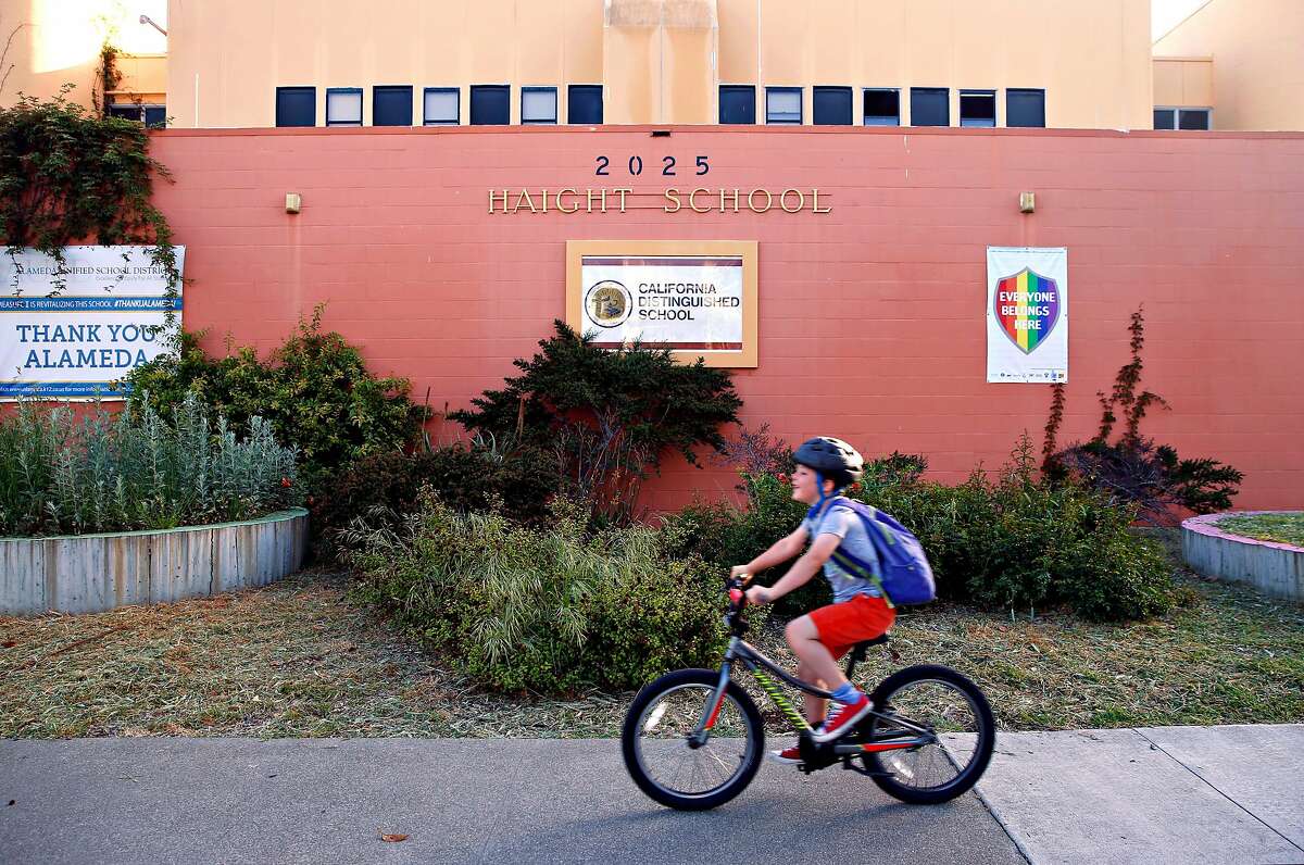 A student arrives for a day of classes at Haight Elementary School on a bicycle in Alameda, Calif. on Thursday, April 25, 2019. School district officials are changing the name of the school to Love Elementary after it was discovered that former California Governor Henry Huntley Haight had racist tendencies.