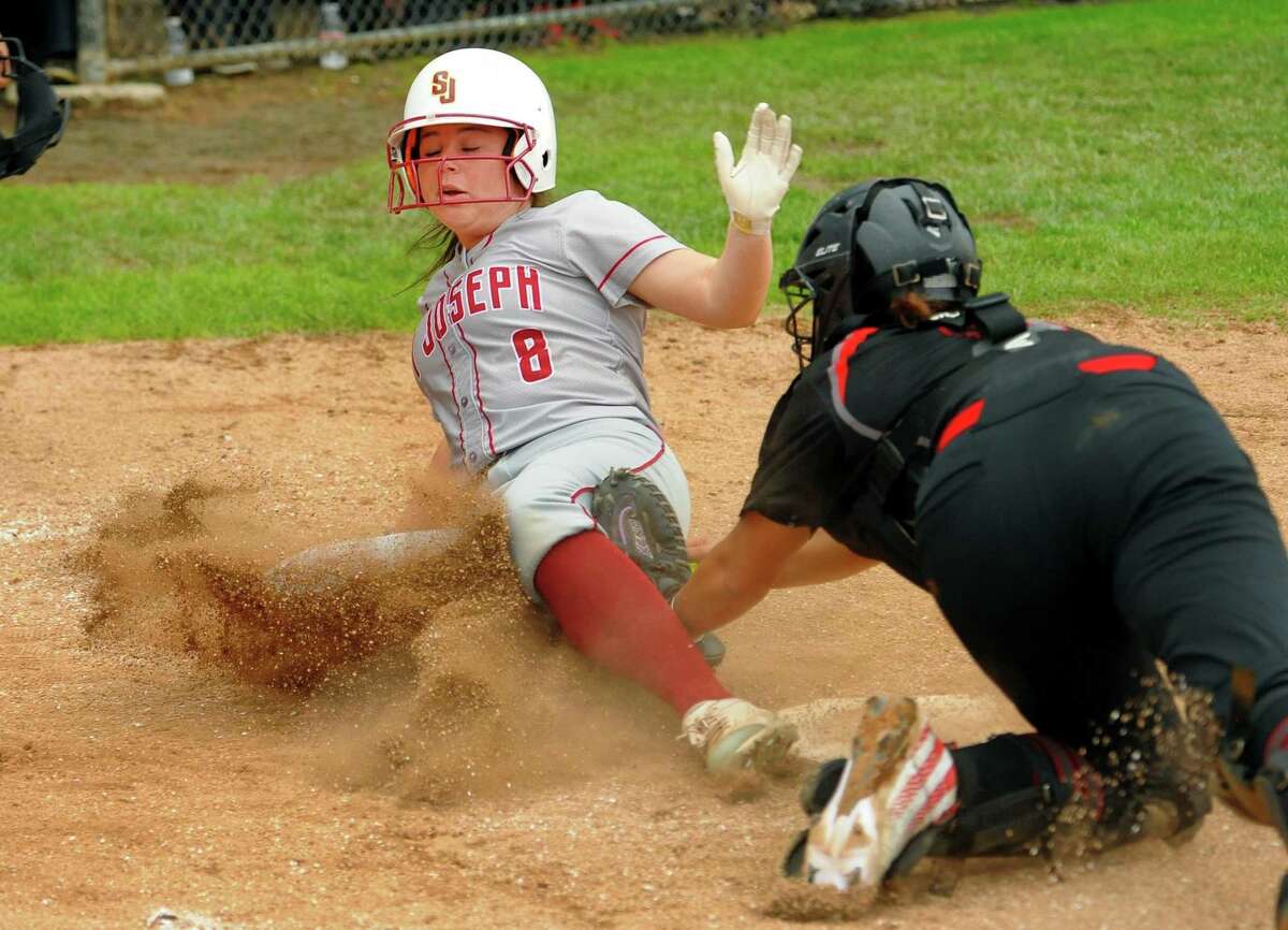 St. Joseph's Kaitlin Capobianco (8) slides into homeplate to score as Cheshire catcher Jade Barnes (6) attempts to make the teg during softball action in Trumbull, Conn., on Wednesday April 25, 2019.
