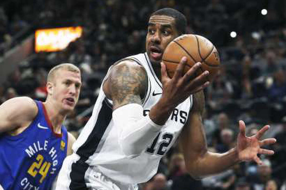 LaMarcus Aldridge saves a loose ball undet the rim and looks for an open teammate as the Spurs host the Nuggets in game 6 of the first round of the Western Conference playoffs at the Alamodome on April 25, 2019.