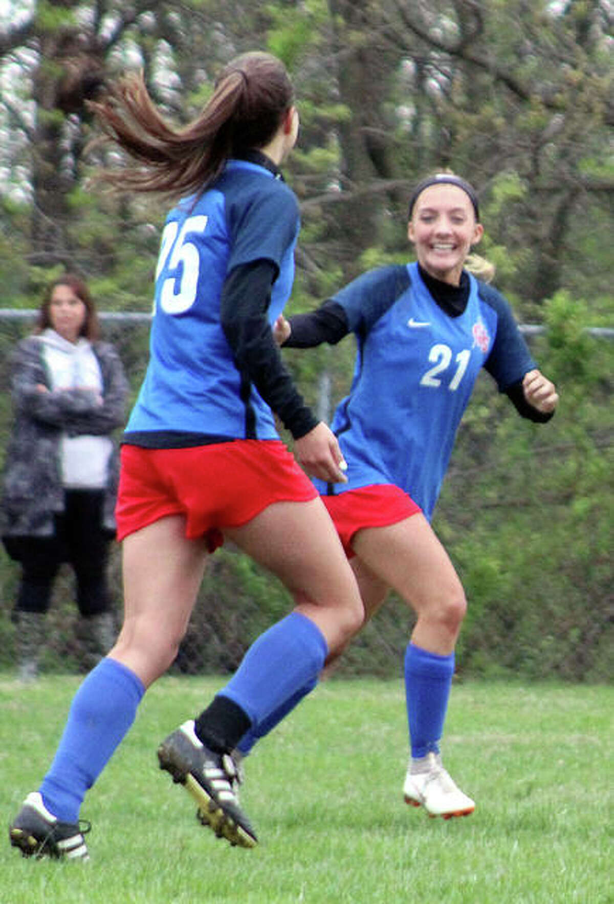 Gabby Marchirori (25) is congratulated by Carlinville teammate Skylar Nickel after scoring a goal in the first half Thursday against Roxana in Carlinville.