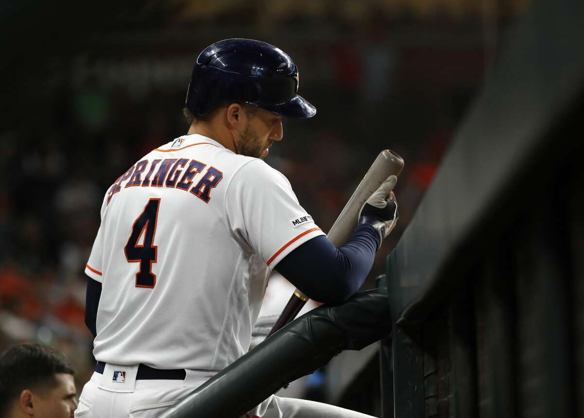 Houston Astros designated hitter George Springer (4) looks at his bat in the dugout during the seventh inning of an MLB baseball game at Minute Maid Park, in Houston, Thursday, April 25, 2019.