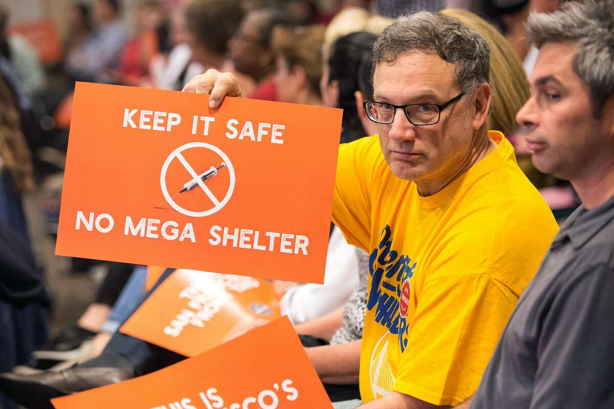 Bruce Guldetsky holds a sign during the Port Commission meeting at Ferry Building that will determine whether a homeless navigation center/shelter will be built on the Embarcadero. Tuesday, April 23, 2019. San Francisco, Calif.