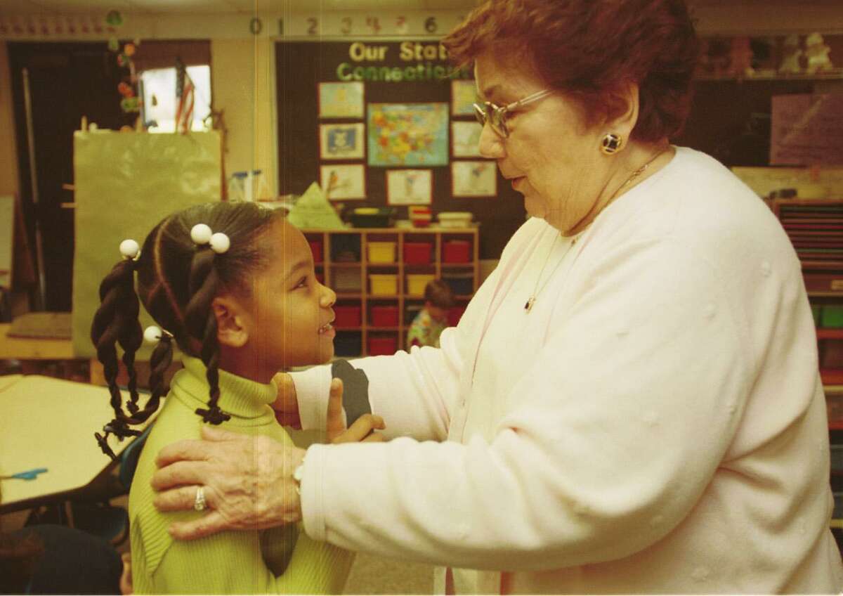Foster Grandparent Lucille Ruggiero speaks with Elementary School Nakeira Morehead in a kindergarten classroom in this archive shot.