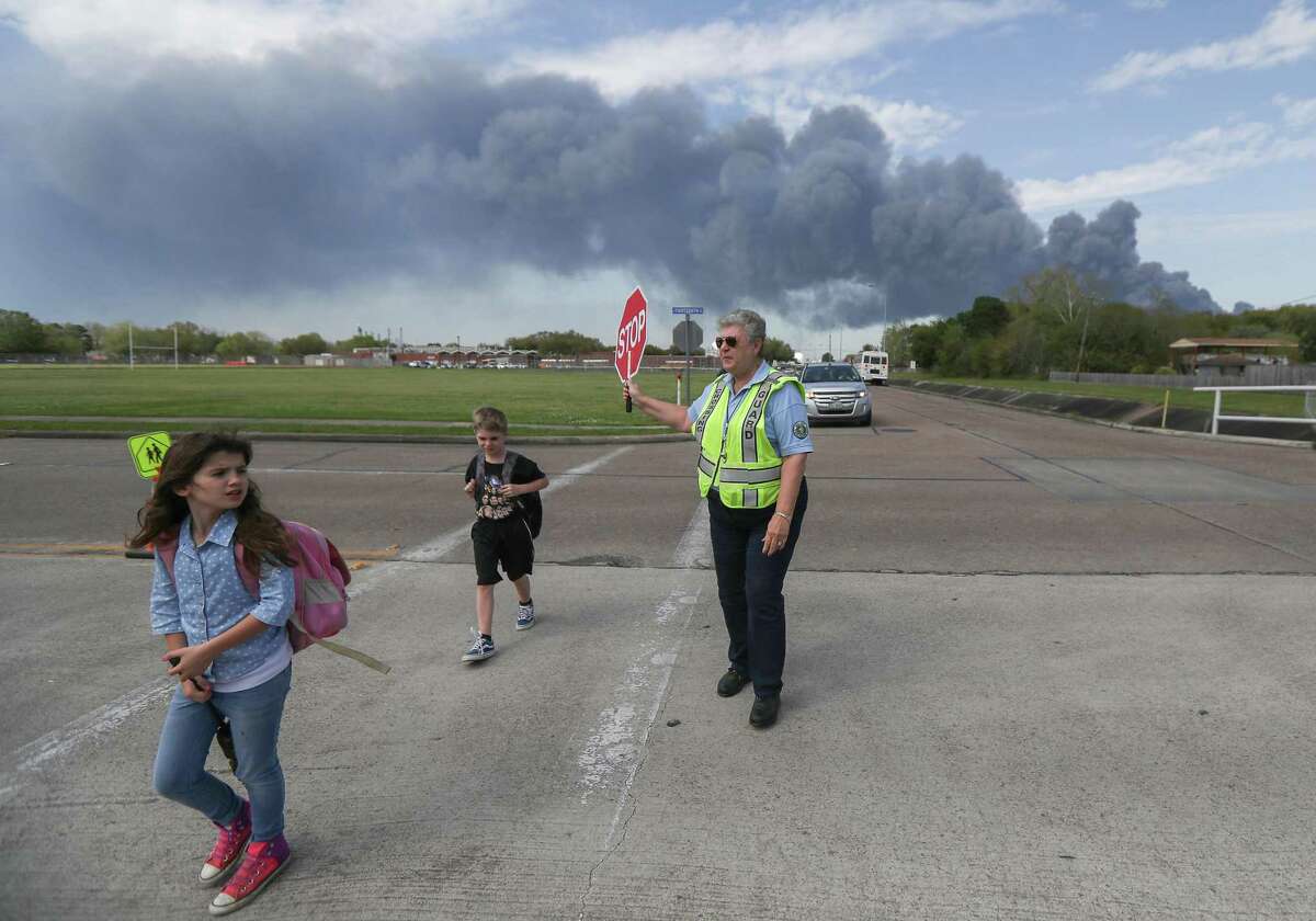 Deer Park PD Crossing Guard Adell Boren makes sure students are safe as they cross East 13th and Meadowlark Streets in spite of a chemical fire burning nearby Tuesday, March 19, 2019, in Deer Park.