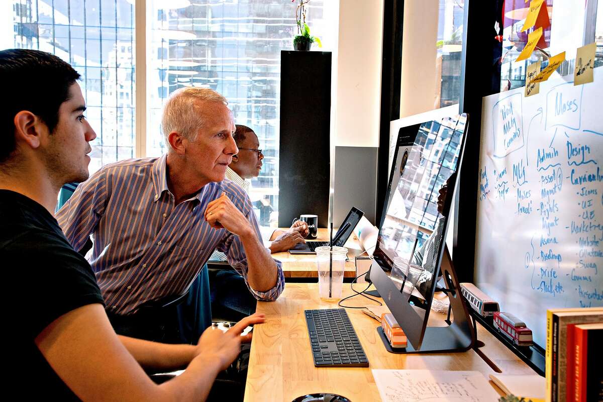 Derek Gordon (center), chief operating officer of the new online Calbright community college, works with Moses Maynez at WeWork in Oakland.