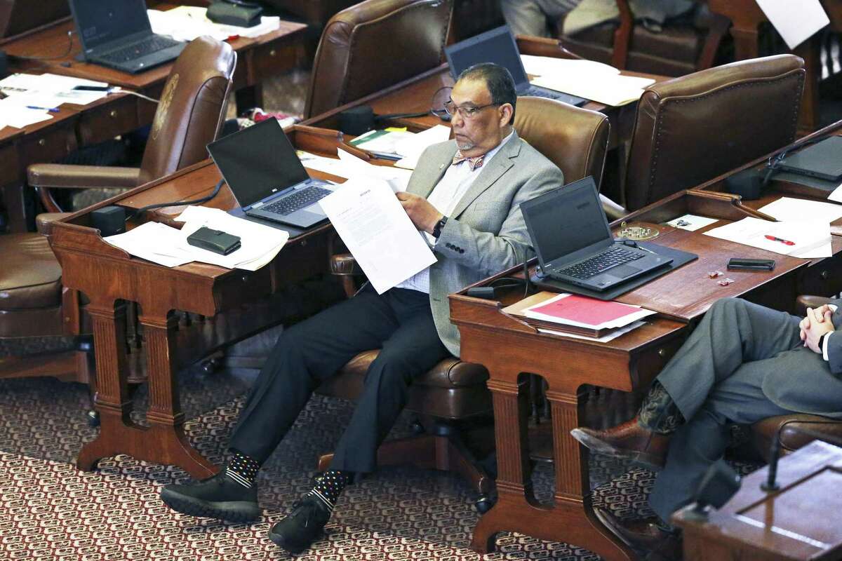 Rep. Joe Deshotel, D-Beaumont, stretches out into the aisle as he reviews printed material as the Texas House of Representatives takes up the budget bill on March 27, 2019.