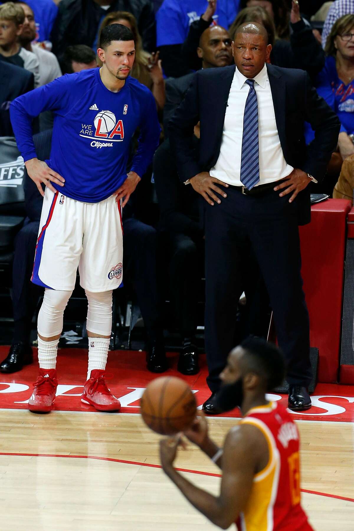 Los Angeles Clippers guard Austin Rivers (25) stands with his father, Clippers head coach Doc Rivers, as Houston Rockets guard James Harden (13) shoots a free throw during the second half of Game 3 of the NBA Western Conference semifinals at Staples Center on Friday, May 8, 2015, in Los Angeles. ( Karen Warren / Houston Chronicle )