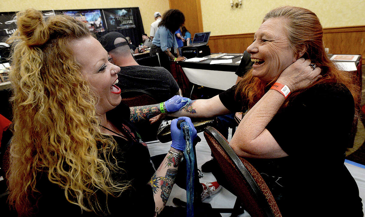 Tattoo artist Carly Bird jokes with Vonda Griffith as she gives her a colorful owl tattoo during the Beaumont, Texas Tattoo Expo, sponsored by Ink Masters Tattoo Show Friday at the MCM Elegante Hotel. The expo continues through the weekend - Saturday 11 a.m. - 11 p.m. and Sunday 11 a.m - 9 p.m. Over one hundred artists and other vendors offered tattoos and piercing on site, in addition to showcasing their skills, new trends in tattooing and related products. Photo taken Friday, April 26, 2019 Kim Brent/The Enterprise