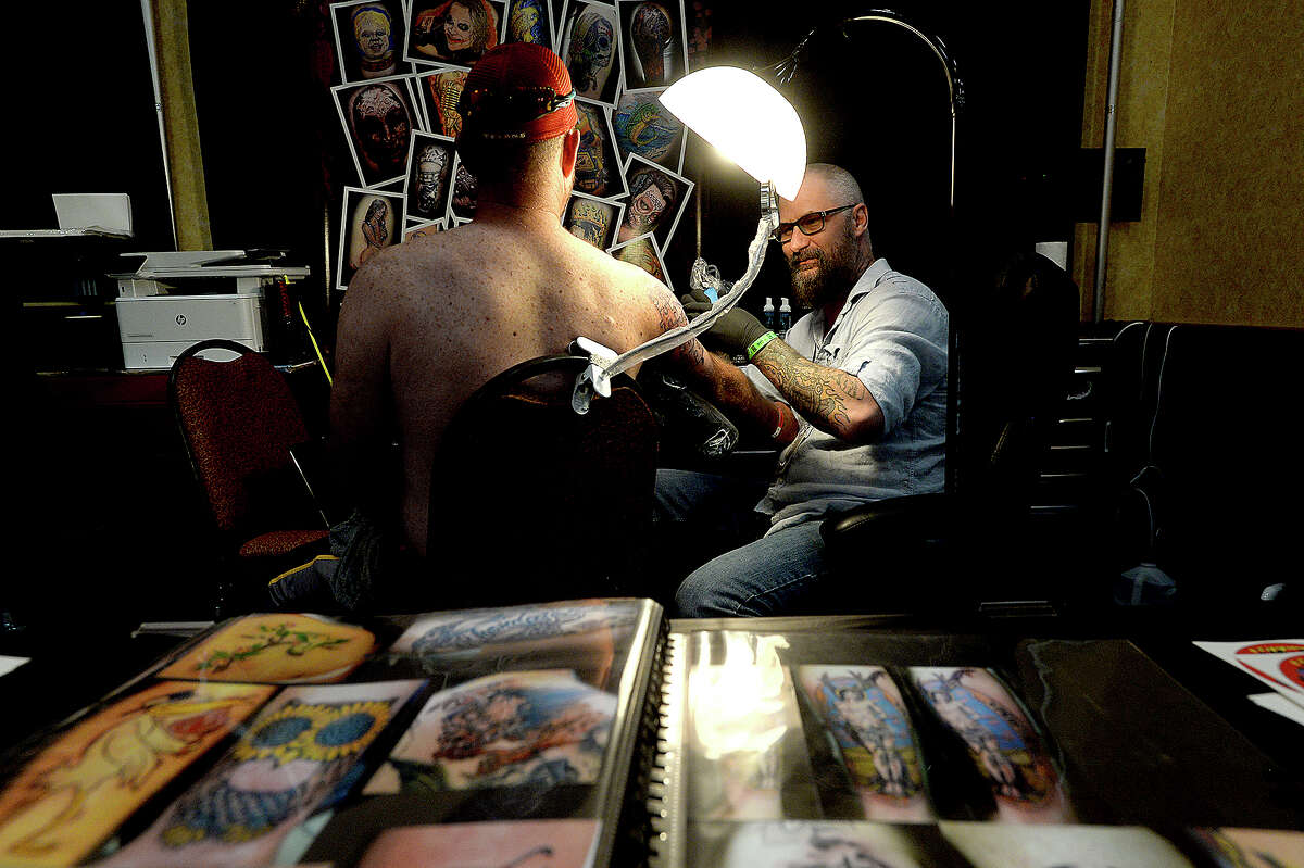 Bridge City-based tattoo artist Flipper gives a first tattoo to Mike Lund during the Beaumont, Texas Tattoo Expo, sponsored by Ink Masters Tattoo Show Friday at the MCM Elegante Hotel. The expo continues through the weekend - Saturday 11 a.m. - 11 p.m. and Sunday 11 a.m - 9 p.m. Over one hundred artists and other vendors offered tattoos and piercing on site, in addition to showcasing their skills, new trends in tattooing and related products. Photo taken Friday, April 26, 2019 Kim Brent/The Enterprise
