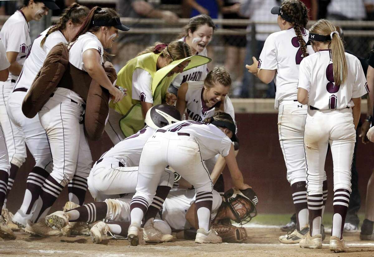 Magnolia’s Alex Dubose is swarmed by her teammates after her game-winning home run.