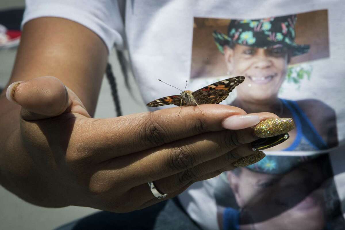 Stacey Bryant, 34, holds a butterfly with the photo of missing person Veronda Kay Sanders on the background during a Missing in Harris County Day butterfly release ceremony on Saturday, April 27, 2019, in Houston.