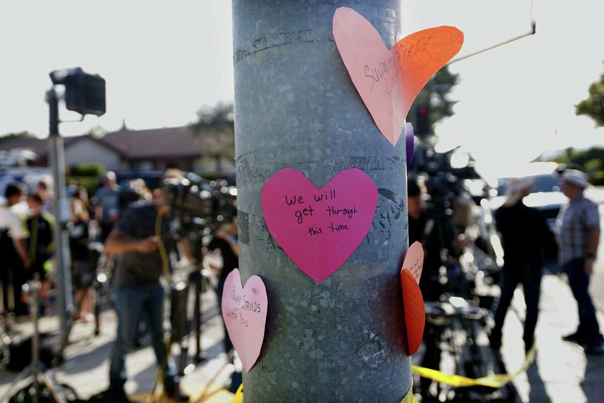 Hand-written notes are displayed on a light post across the street from the Chabad of Poway Synagogue after a shooting on Saturday in Poway, Calif.