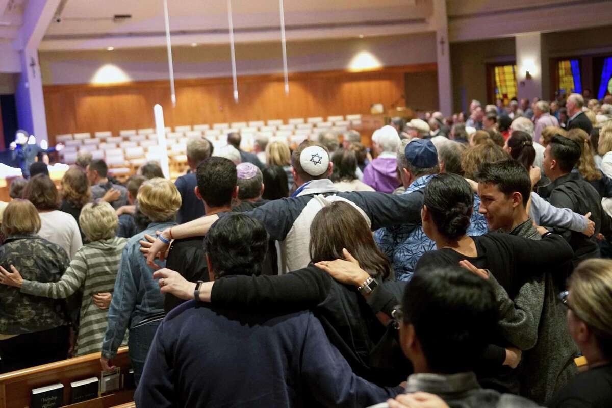 TOPSHOT - Mourners participate in a vigil for the victims of the Chabad of Poway Synagogue shooting at the Rancho Bernardo Community Presbyterian Church on Saturday in Poway, Calif.