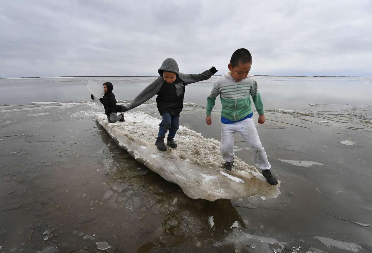 Schoolchildren play on melting ice on April 18 in the climate change-affected Yupik Eskimo village of Napakiak on the Yukon Delta in Alaska.