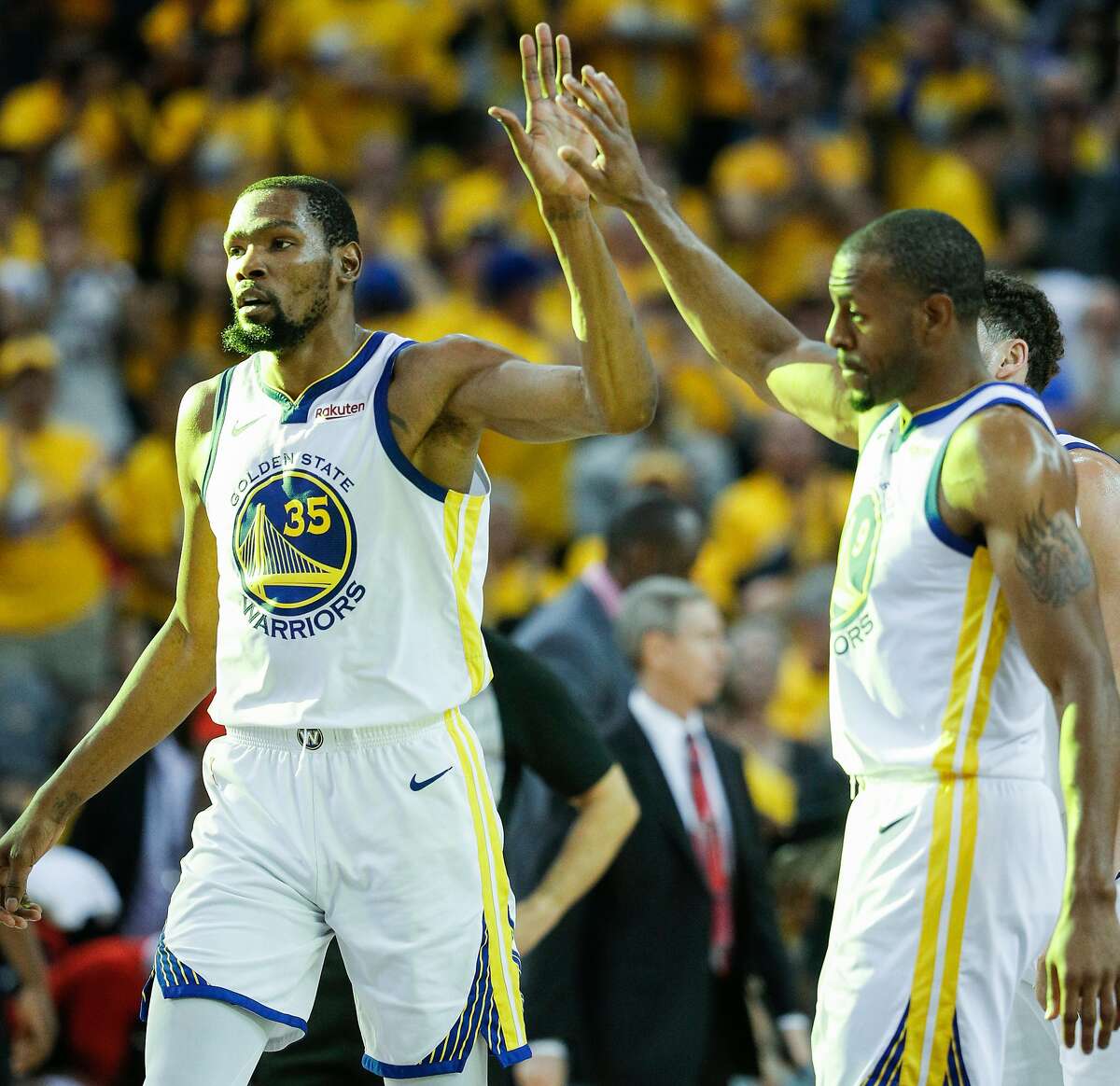 Golden State Warriors Kevin Durant gets a high five from Andre Iguodala in the third quarter during game 1 of the Western Conference Semifinals between the Golden State Warriors and the Houston Rockets at Oracle Arena on Sunday, April 28, 2019 in Oakland. The Warriors paid tribute to Durant and Iguodala, who both are no longer with the team, with videos they posted to social media on Wednesday.