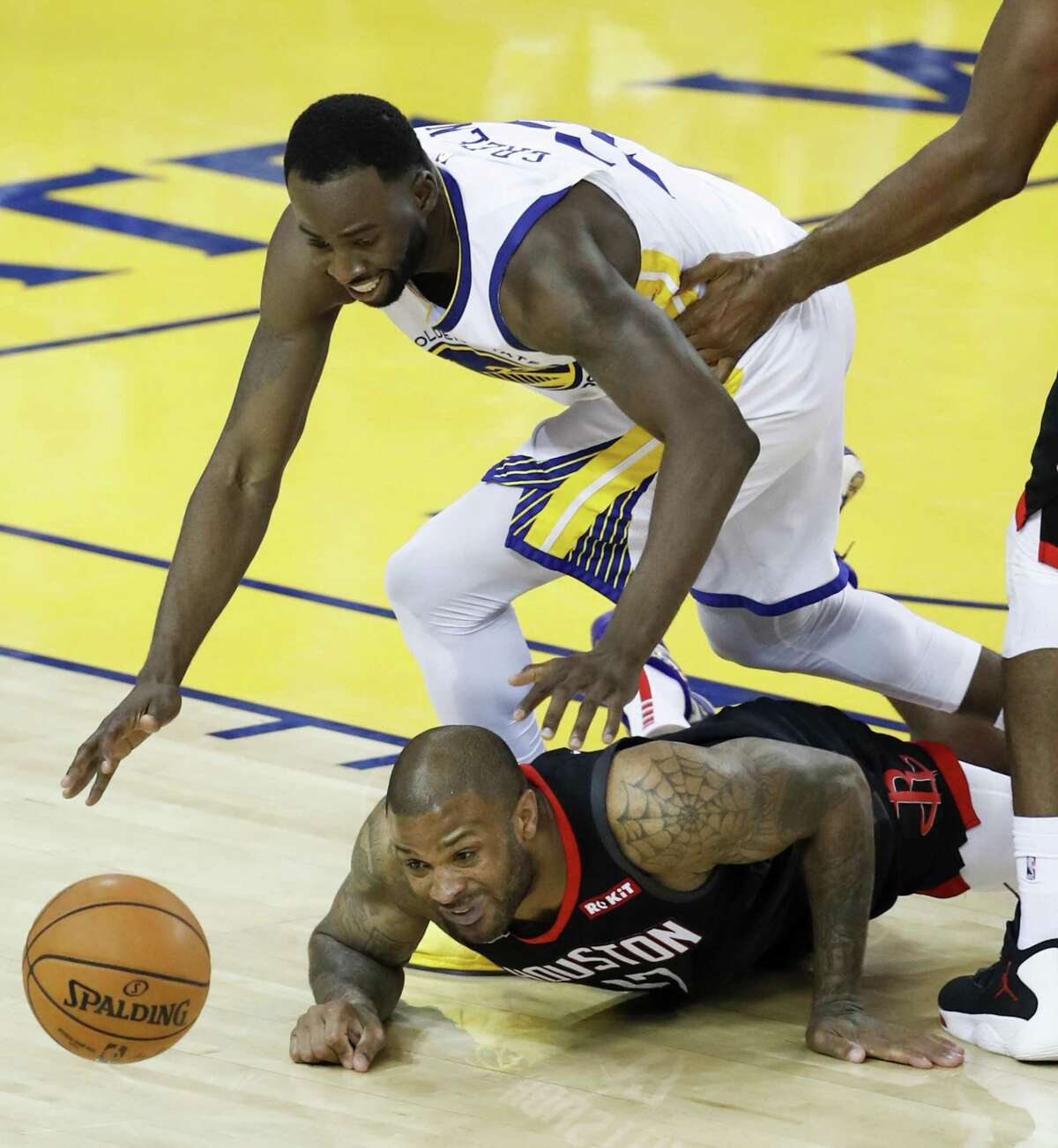Golden State Warriors Draymond Green and Houston Rockets P.J. Tucker scramble for a loose ball in the fourth quarter during game 1 of the Western Conference Semifinals between the Golden State Warriors and the Houston Rockets at Oracle Arena on Sunday, April 28, 2019 in Oakland, Calif.