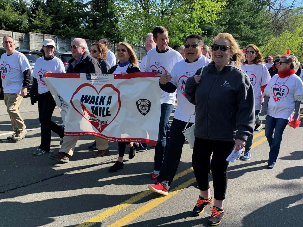 Helping carry the banner at Saturday's Walk are from left, State Rep. Cristin McCarthy-Vahey; First Selectman Mike Tetreau; State Rep. Brenda Kupchick; John Hamilton; State Sen. Tony Hwang and Deb Greenwood.