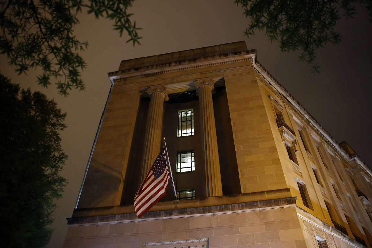 An American flag flies outside the Department of Justice early Thursday, April 18, 2019, in Washington. The Justice Department on Thursday is expected to release a redacted version of special counsel Robert Mueller's report on Russian election interference and President Donald Trump's campaign. (AP Photo/Patrick Semansky)