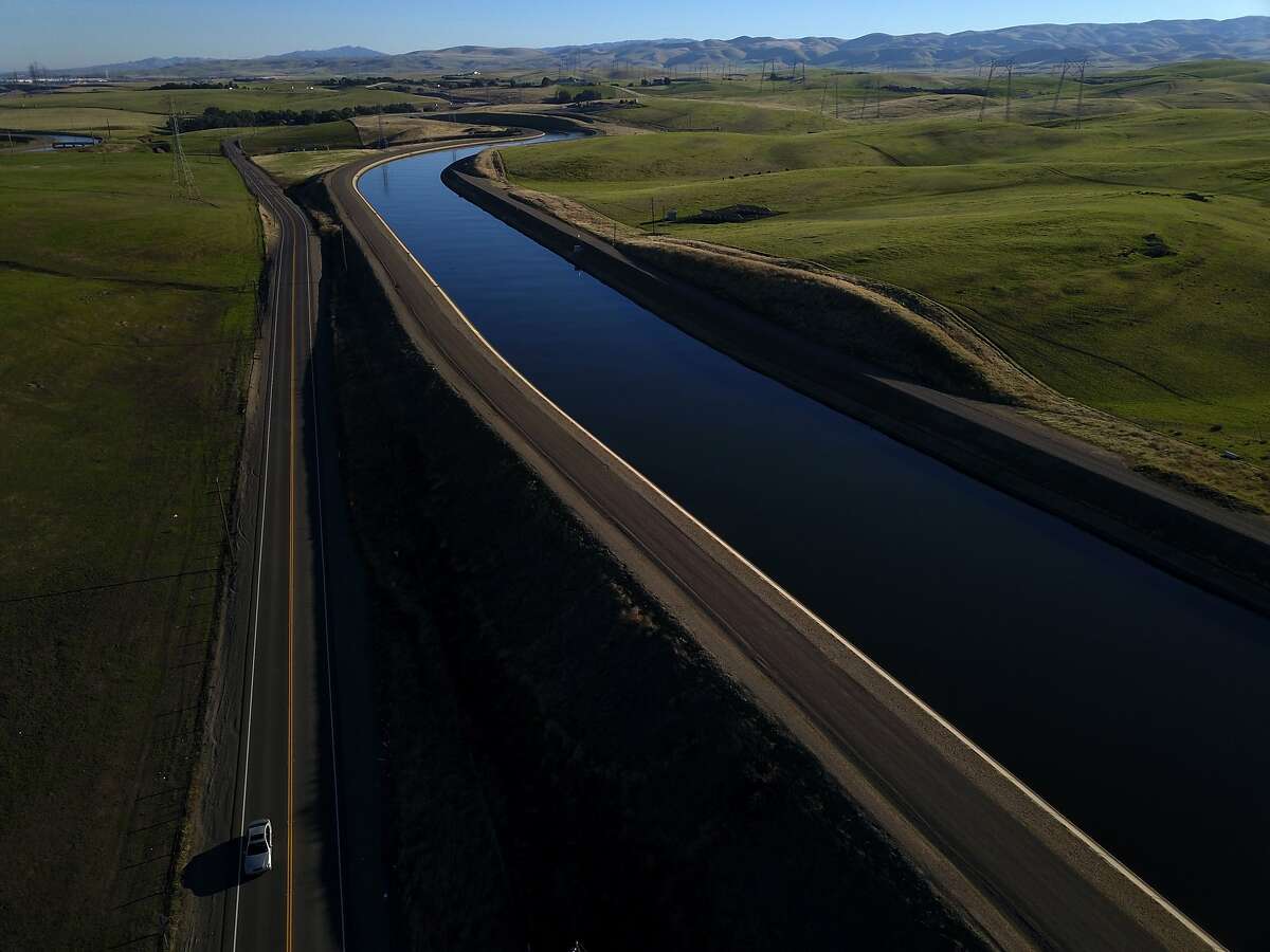 A car drives on Mountain House Road alongside the Governor Edmund G. Brown California Aueduct that carries water from the Sacramento-San Joaquin Delta outside Byron, Calif., to Southern California on Tuesday, December 11, 2018. On Wednesday, the Legislature is expected to vote on a massive water bill which could decide the fate of the state's water, pitting environmentalists and sportsmen against farmers and city dwellers. No matter how the vote goes, someone will be unhappy, either the cities and suburbs, or the ranchers/farmers or the environmentalists.