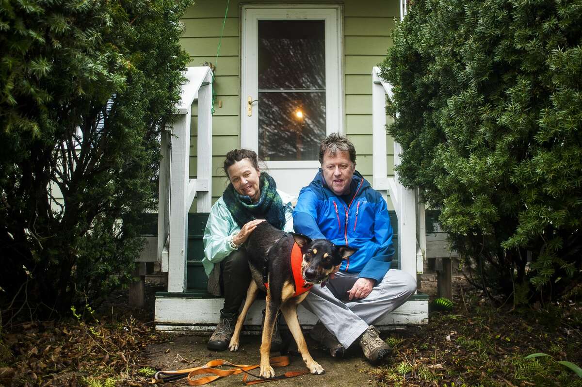 Deirdre Crean, left, John McKelvey, right, and their three-legged, 2-year-old German shepherd mix named Jack, center, pose for a portrait on their front porch on Monday, April 29, 2019 in Midland. For more photos go to www.ourmidland.com. (Katy Kildee/kkildee@mdn.net)