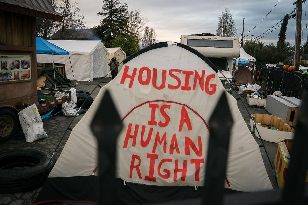 A message is painted on a tent standing in the Dignity Village homeless encampment in Oakland, Calif. on Wednesday, Dec. 5, 2018.
