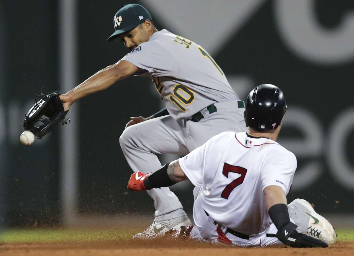 Oakland Athletics shortstop Marcus Semien (10) tries unsuccessfully to make the force on Boston Red Sox's Christian Vazquez (7) during the third inning of a baseball game at Fenway Park, Monday, April 29, 2019, in Boston. Oakland Athletics second baseman Jurickson Profar was charged with a throwing error on the play. (AP Photo/Charles Krupa)