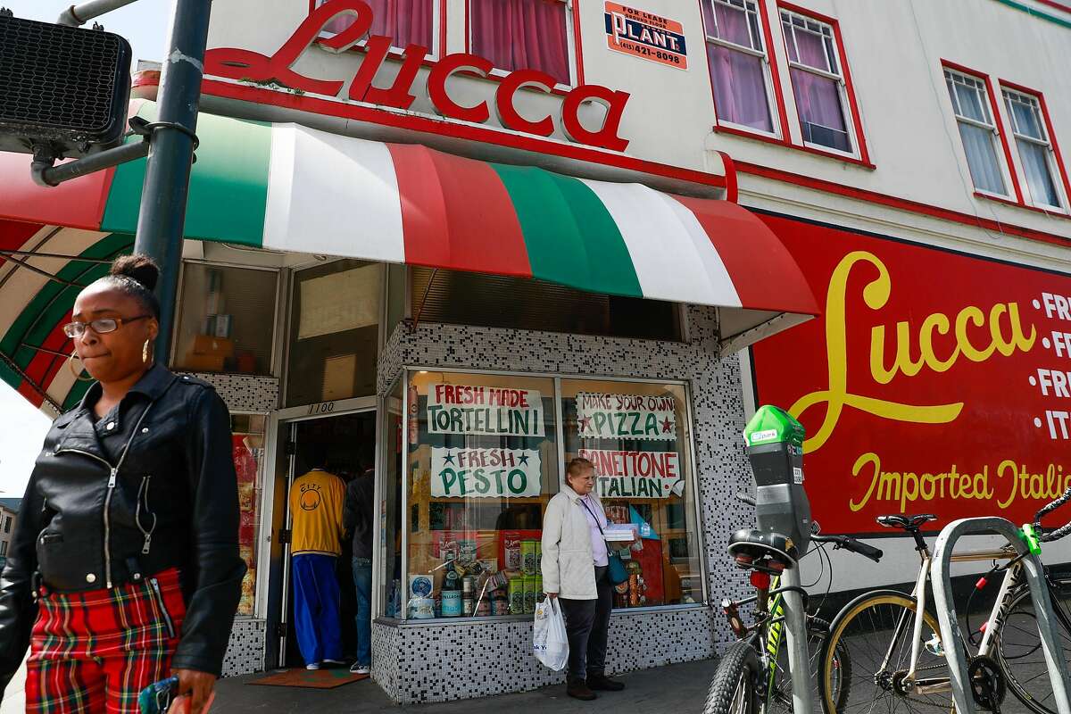 People pass by Lucca Ravioli on it's final day open after 90 years of business on Valencia Street in San Francisco, California, on Tuesday, April 30, 2019.