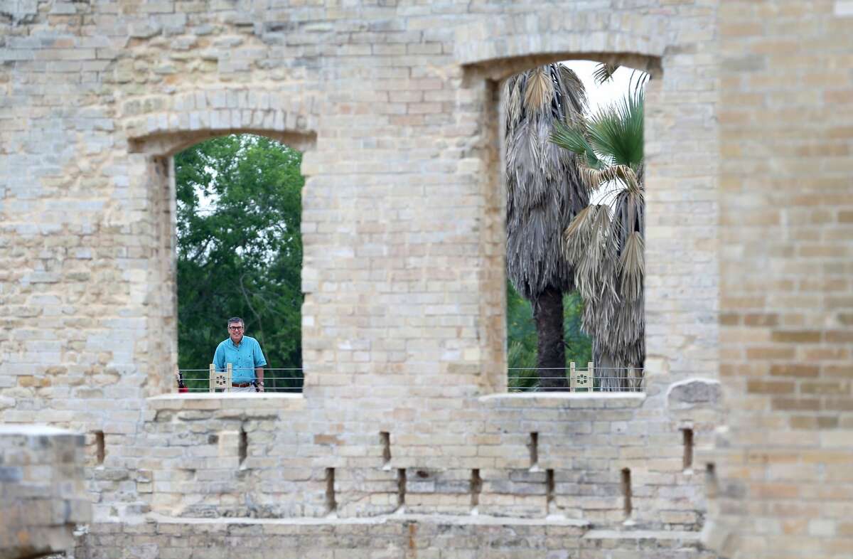A person looks Tuesday, April 30, 2019 through a former window of the now stabilized Hot Wells Hotel ruins which are the centerpiece of the just opened Hot Wells of Bexar County park.