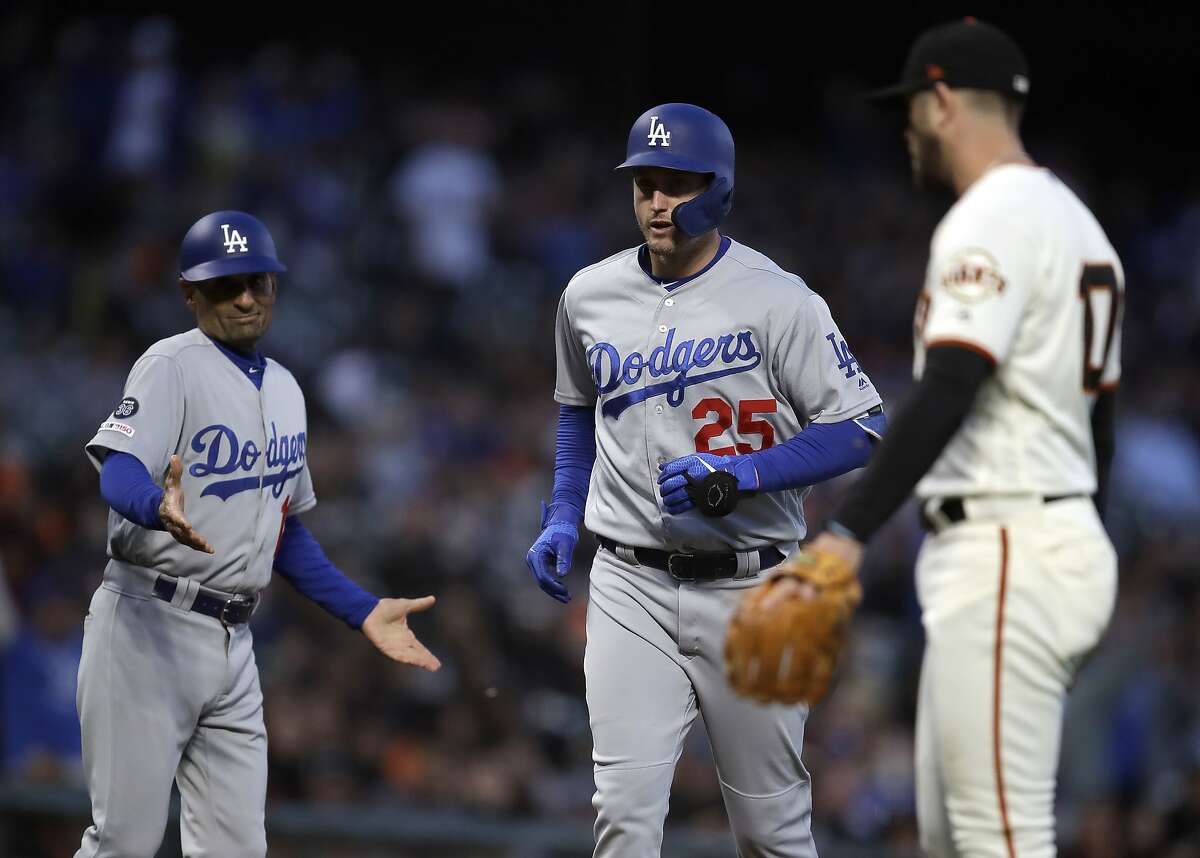 Los Angeles Dodgers third base coach Dino Ebel, left, reacts as David Freese (25) runs the bases after hitting a three run home run off San Francisco Giants' Drew Pomeranz, right, in the fourth inning of a baseball game Tuesday, April 30, 2019, in San Francisco. (AP Photo/Ben Margot)