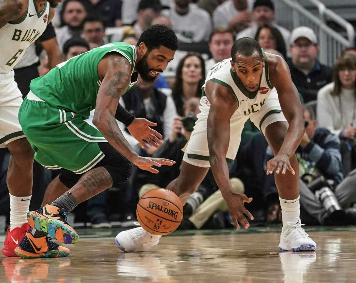 Milwaukee Bucks' Khris Middleton and Boston Celtics' Kyrie Irving go after a loose ball during the first half of Game 2 of a second round NBA basketball playoff series Tuesday, April 30, 2019, in Milwaukee. (AP Photo/Morry Gash)