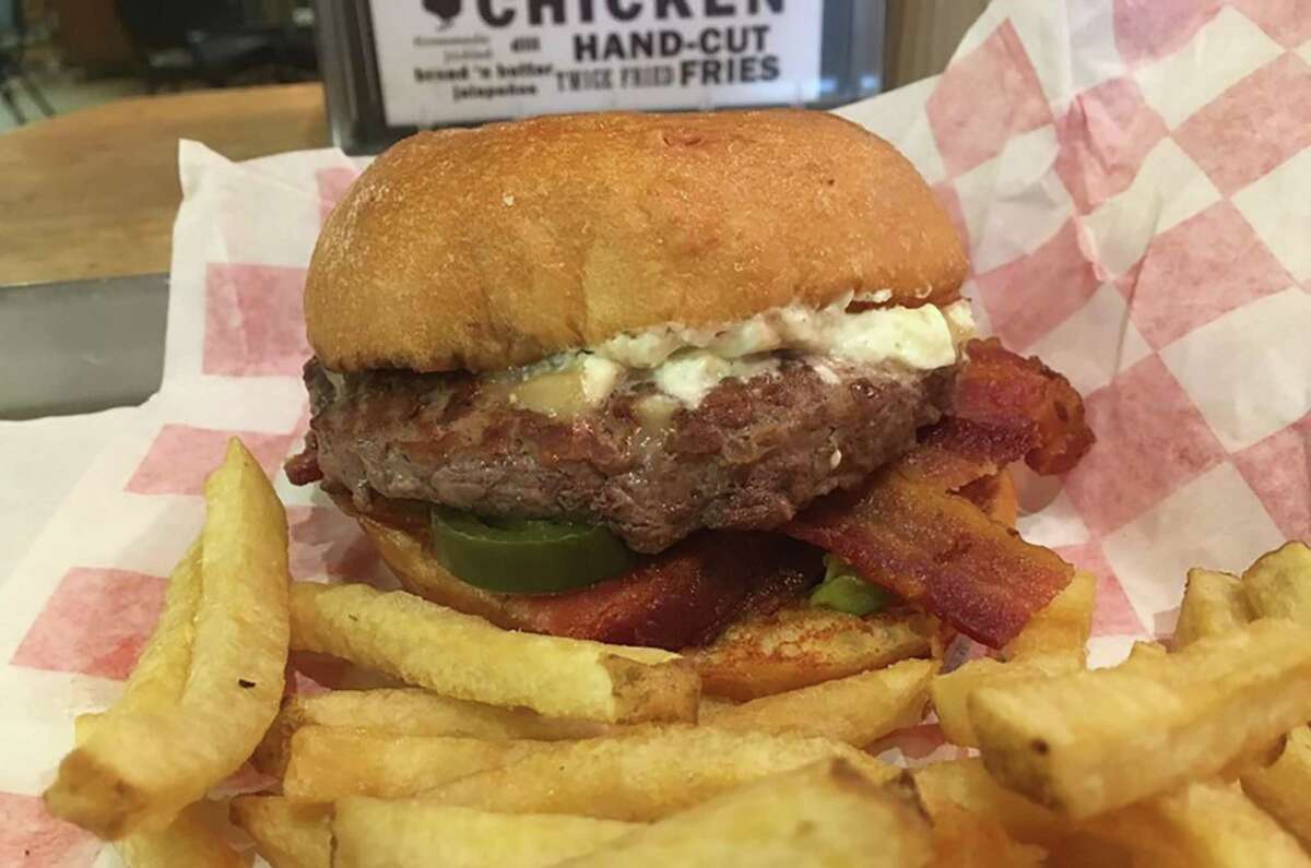 The Jalapeño Popper Burger is topped with ranch-infused cream cheese, shredded cheddar, four slices of bacon and pickled jalapenos on a brioche bun.