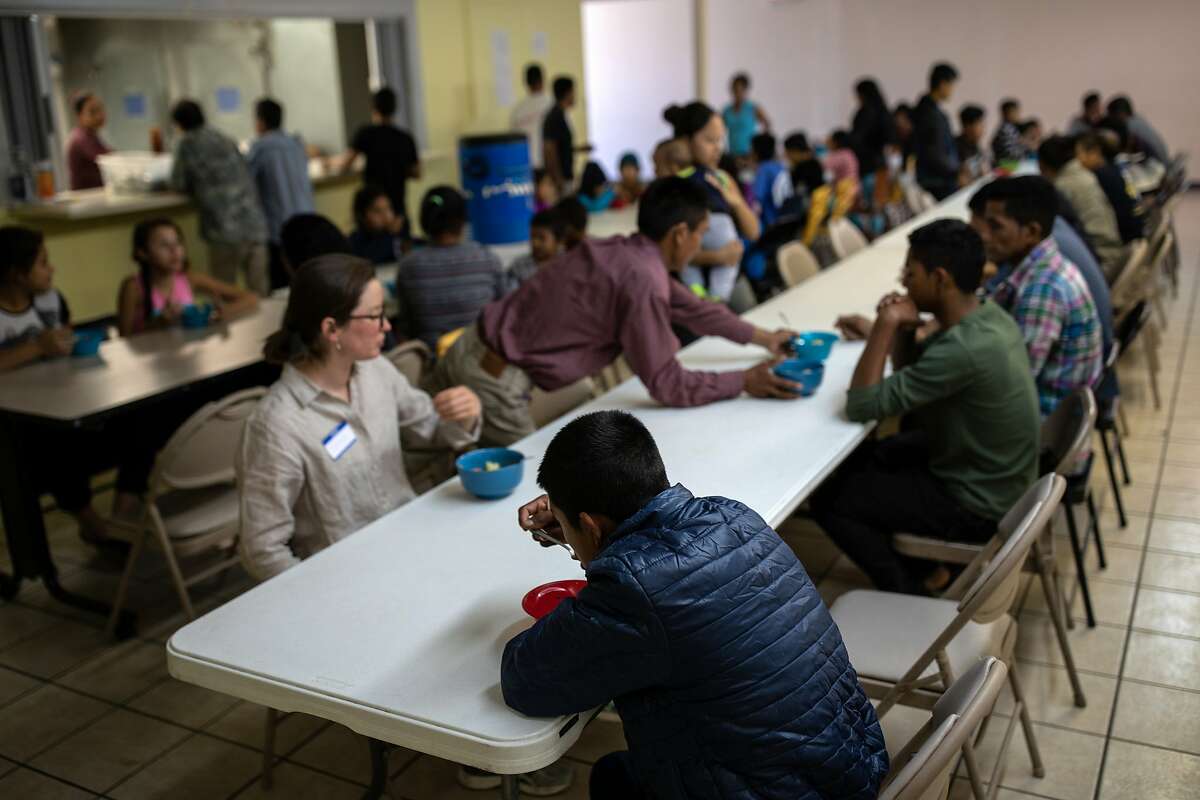 FILE -- Migrants and volunteers eat lunch at a shelter in El Paso, Texas, April 3, 2019. A 16-year-old Guatemalan boy who was placed in a Texas shelter for migrant children and teenagers after entering the United States has died in federal custody, officials said on May 1. (Tamir Kalifa/The New York Times)
