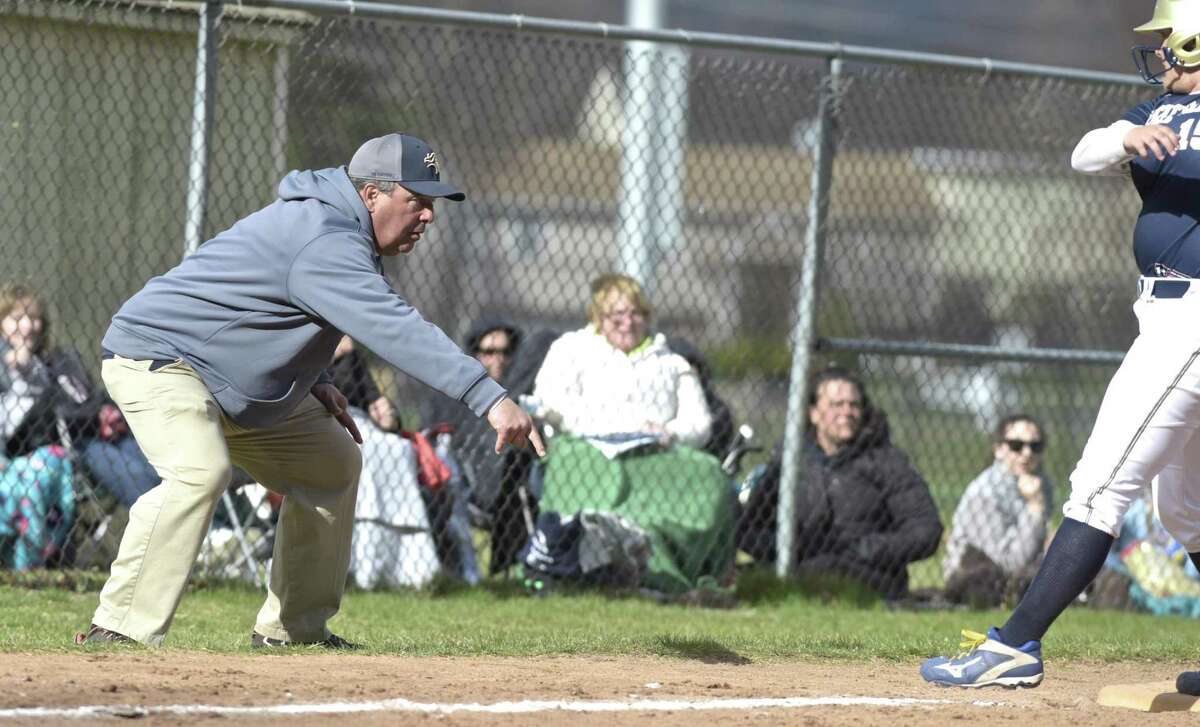 Notre Dame head coach Jeff Bevino tries to get the runner to slide into third during the girls softball game between Notre Dame - Fairfield and New Milford high schools, Wednesday afternoon, April 18, 2018, at New Milford High School, New Milford, Conn.