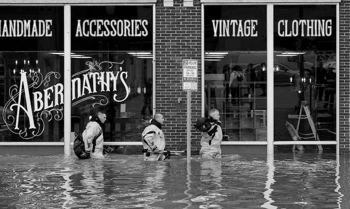 Firefighters move building to building checking for people trapped after the floodwall failed, sending Mississippi River floodwater into several blocks of downtown Davenport, Iowa.